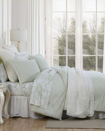 Heirloom Ditzy Cotton Green Comforter Set on a bed in a room on a bed with a large window behind it