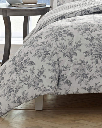 Annalise Floral Grey Duvet Cover Bonus Set - View of duvet on bed showing floral print and stripe reverse 