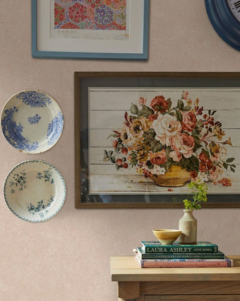 Brindley Plaster Pink Wallpaper on a wall behind wall art and plates