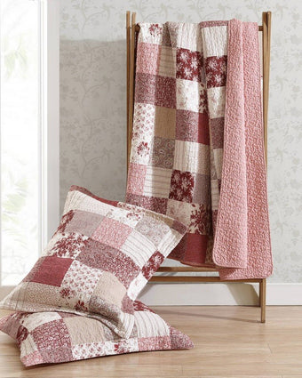 Celina Patchwork Cranberry Cotton Reversible Quilt Set view of quilt on a ladder and shams