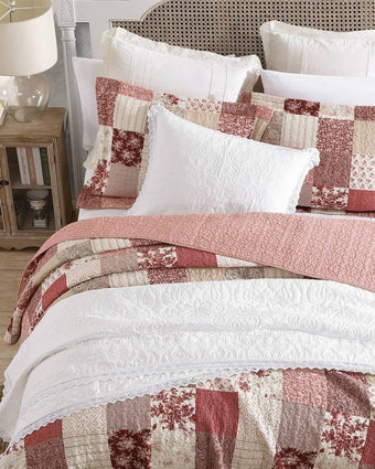 Celina Patchwork Cranberry Cotton Reversible Quilt Set aerial view of quilt and shams on a bed