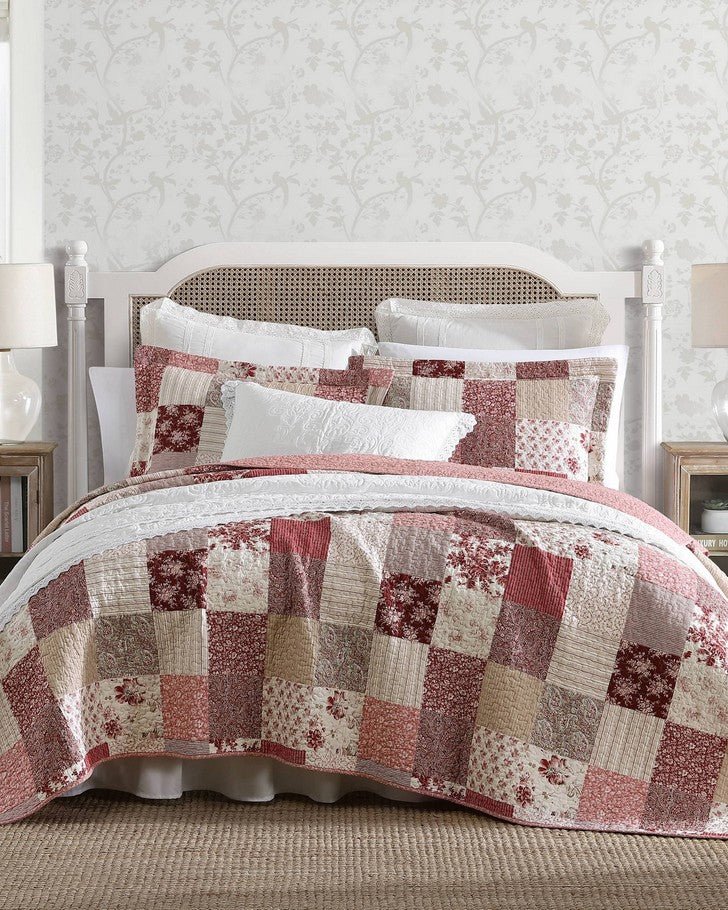 Celina Patchwork Cranberry Cotton Reversible Quilt Set front view of quilt and shams on a bed