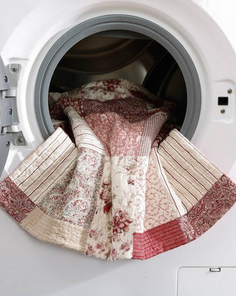 Celina Patchwork Cranberry Cotton Reversible Quilt Set view of quilt in a dryer