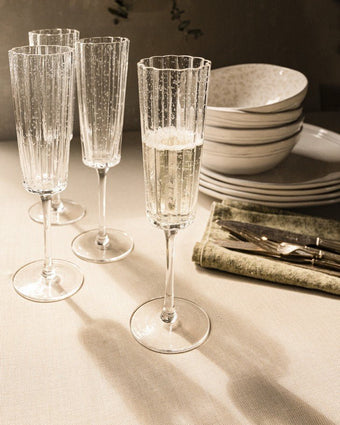 Clear Set of 4 Champagne Glass Set view of glasses and dinnerware on dinner table