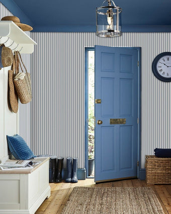 Farnworth Stripe Smoke Blue Wallpaper on a wall in an entry way with a blue door