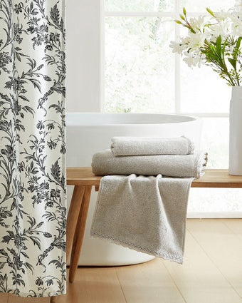 Juliette Lace Hem Grey 3 Piece Towel Set View of towels folded on bench