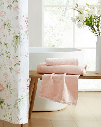 Juliette Lace Hem Blush 3 Piece Towel Set View of folded towels on bench