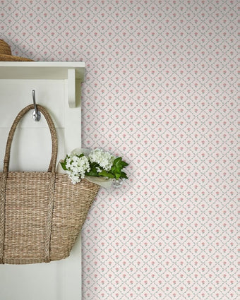 Kate Coral Pink Wallpaper on a wall behind a white cupboard