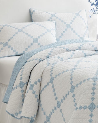 Melody Patchwork Blue Quilt - View of quilt and coordinating shams on bed