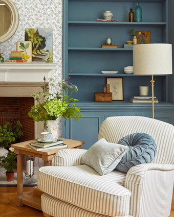 Misterton Trail Pale Seaspray Blue Wallpaper on a wall above a fireplace next to a blue painted bookshelf