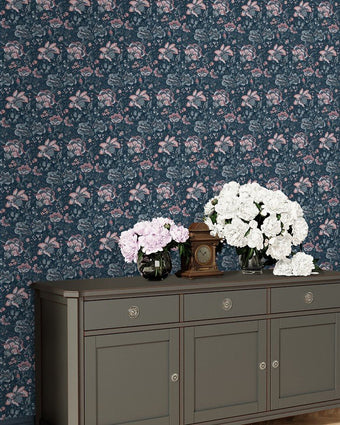Portia Dark Seaspray Wallpaper on a wall behind a dresser and flowers.