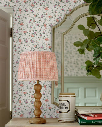 Priory Coral Pink Wallpaper on a wall behind a lamp and mirror