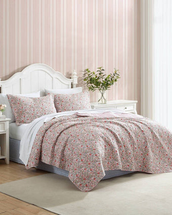 Rowena Pink Quilt - Side view of quilt and shams on a bed