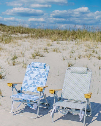 Sailboats Dune High Backpack Beach Chair on the beach during a sunny day.