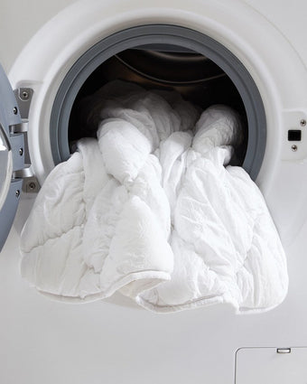Susanna White Microfiber Quilt Set View of quilt in a dryer