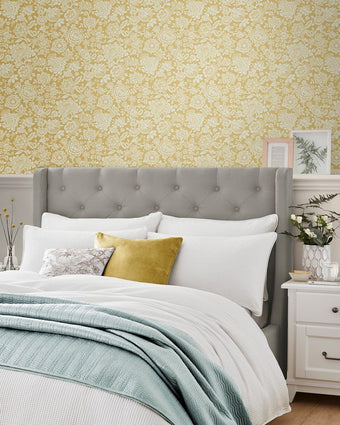Trailing Laurissa Pale Ochre Yellow Wallpaper view of wallpaper on a wall in a room