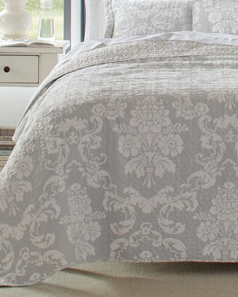 Venetia Grey Reversible Quilt Bonus Set view of corner of quilt on a bed