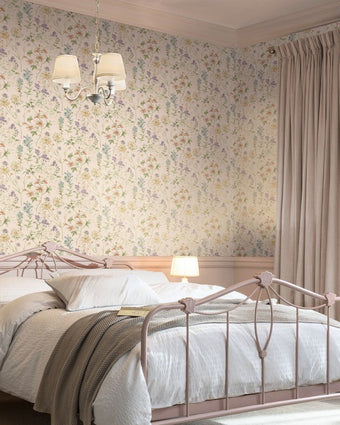 Wild Meadow Chalk Pink Wallpaper on a wall behind a metal bed with white bedding